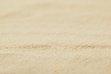 Fototapeta na wymiar selective focus of textured sandy surface on beach in summertime