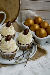 Carrot Easter cupcakr with chocolate egg on top and whipped cream frosting close up seective focus