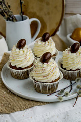 Carrot Easter cupcakr with chocolate egg on top and whipped cream frosting close up seective focus