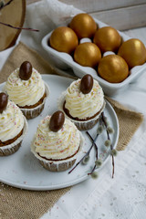 Carrot Easter cupcakr with chocolate egg on top and whipped cream frosting close up seective focus