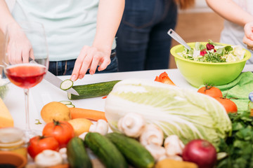 Healthy food and balanced eating. Salad recipes and cooking. Female hands chopping cucumber