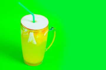 tea with apple and cocktail tube on a green background