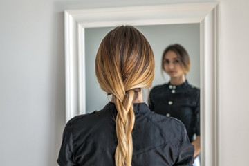 woman girl with ombre hairstyle in braid in front of mirror © Shevdinov