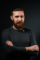 Portrait of a bearded man on a black background.
