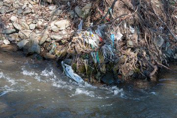 Plastic and foam garbage floating on the surface of the river