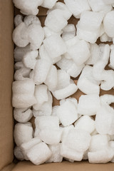 Fototapeta na wymiar box packaging material with white S-shaped polystyrene peanuts inside - Bilder