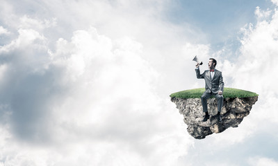 Businessman floating on island in sky and announcing something in loudspeaker