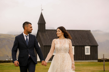 Beautiful wedding couple posing with black old church