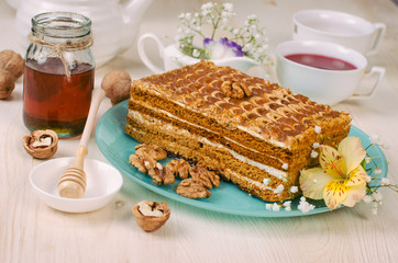 Still life on the table. Sweet cake honey and a hot drink .