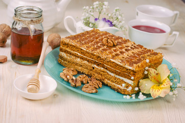 Still life on the table. Sweet cake honey and a hot drink .