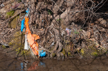 Plastic and foam garbage floating on the surface of the river