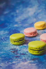 Variety of colorful macarons over a blue background