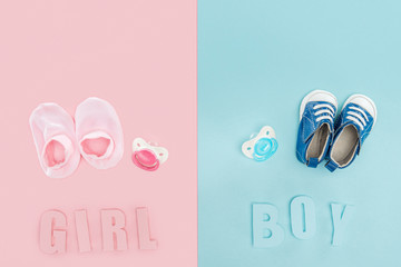 top view of pacifiers, booties, sneakers and boy, girl lettering
