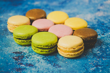 Fototapeta na wymiar Variety of colorful macarons over a blue background
