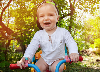 Little boy in a cap rides a bicycle in the park