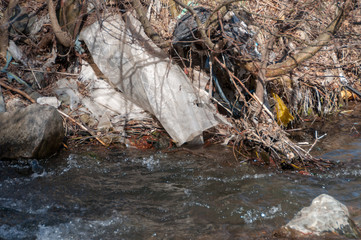 Obraz premium Plastic and foam garbage floating on the surface of the river