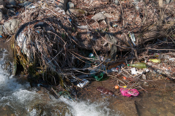 Obraz premium Plastic and foam garbage floating on the surface of the river