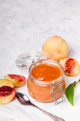 Homemade peach jam with organic fruit. Sweet preserves on a light background, , copy space