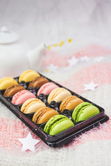 Delicious macarons with a tea in a teapot