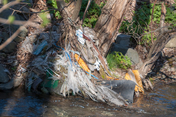 Plastic and foam garbage floating on the surface of the river