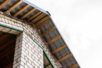 Fototapeta premium Construction of a pitched roof. Sheathing of metal roof. Roof slope.