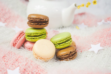Delicious macarons with a tea in a teapot