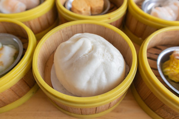 close up of steamed pork bun in bamboo basket