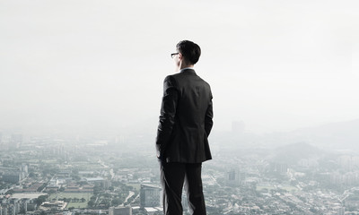 Concept of business success and control with confident boss against cityscape background