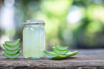 Fresh aloe vera stem slices and gel on wooden table, skin therapy concept