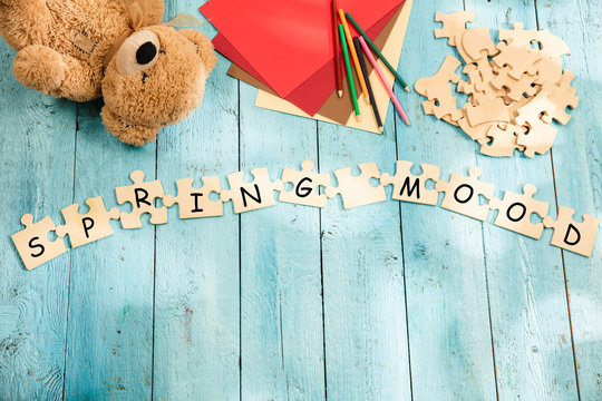 Stationery and words SPRING MOOD made of letters, mock up and pieces of puzzles on wooden background. Concept of family, parenting, children, rest, travel, school break. - Powered by Adobe