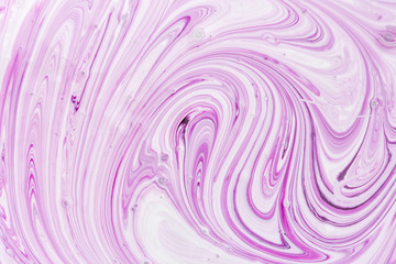 The process of mixing white and light purple paint close-up. Empty abstract background for layouts.