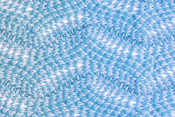 The texture of wool products close-up. Knitted zigzag pattern. Blank blue background for layout.