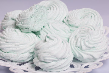 Obraz na płótnie Canvas Homemade marshmallows laid on a plate. Marshmallow with mint, with a green tint. On a white background.