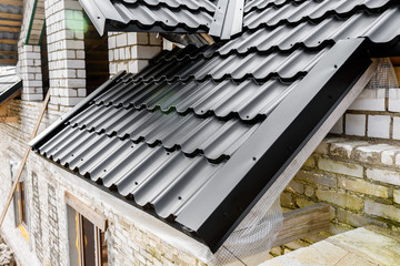 Construction of the roof of the house. Metal tiles.