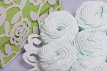 Homemade marshmallows laid on a plate. Marshmallow with mint, with a green tint. Nearby are napkins of light green color.