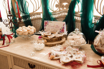 Candy bar. White wedding cake standing of festive table with deserts, tartlet and cupcakes. Wedding.
