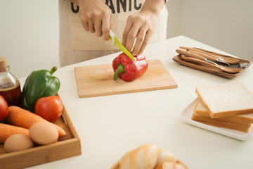 Male hands slicing fresh red bell peppers