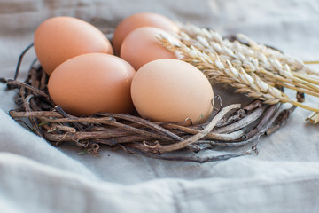 Natural Easter eggs in a wicker nest on a linen napkin.