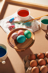 Eggs, colorful paints, brushes, pencils on a wooden background, coloring eggs, preparing for Easter, spring seasonal holiday
