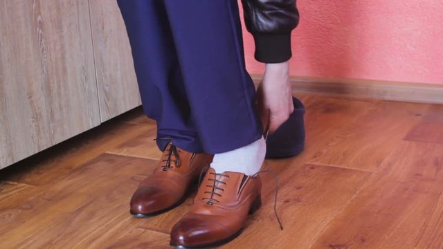 A man wears classic shoes,Man putting on shoes indoors