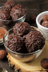 Chocolate ice cream with liquid chocolate on a wooden stand on a dark background. close-up