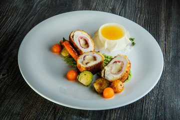 tasty dissected chicken Kiev cutlets with grilled vegetables and yellow sauce