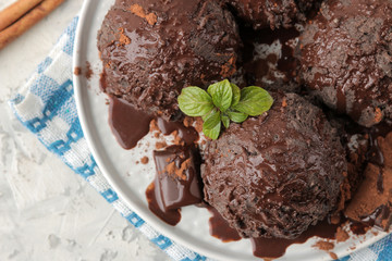 Chocolate ice cream with liquid chocolate on a light concrete background. top view