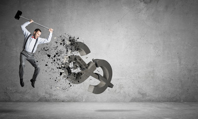 Determined banker man in empty concrete room breaking dollar figure