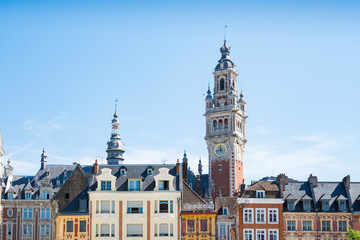 tower of Chamber of commerce, buildings at central town square in Lille, France. Against blue sky....