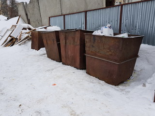 Rusty trash cans on the snow in winter