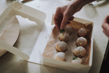 Close up of person putting mint leaf on the pastry
