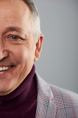 Positive adult man smiling face isolated against the grey background