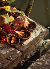  Hindu woman pray sun God, with lighted oil, eathen pot lamp, at dusk,in the bank of lake, during...