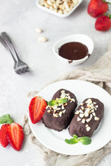 Glazed cheese curds with chocolate, peanut, strawberry and mint on a white plate. Sweet breakfast or dessert. High key.